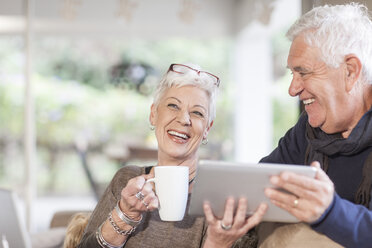 Senior couple with digital tablet and cup of coffee - ZEF005508