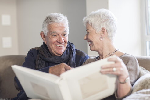 Älteres Paar schaut sich gemeinsam ein Fotoalbum an - ZEF005509