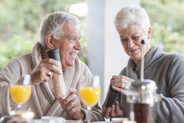 Älteres Ehepaar beim gemeinsamen Frühstück auf der Terrasse - ZEF005532