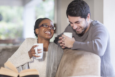 Young couple with coffee cups at home - ZEF005539