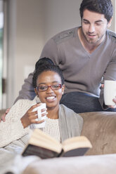 Young couple with coffee cups at home - ZEF005540