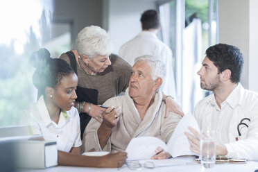 Senior couple at clinic with doctor and nurse - ZEF005572