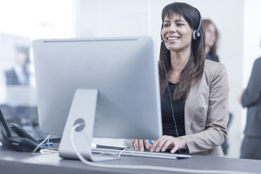 Woman with headset working in office - ZEF005589