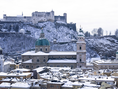 Österreich, Land Salzburg, Salzburg, Altstadt, Blick auf den Salzburger Dom und die Burg Hohensalzburg im Winter, lizenzfreies Stockfoto