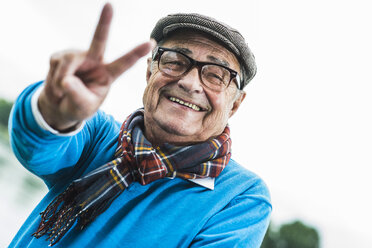 Porträt eines glücklichen älteren Mannes mit Siegeszeichen - UUF004504