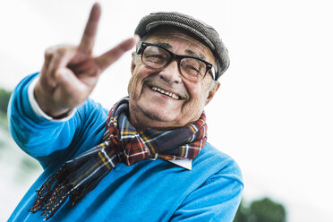 Portrait of happy senior man showing victory sign - UUF004504