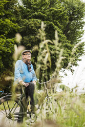 Happy senior man with bicycle - UUF004524