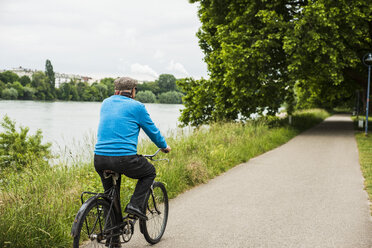 Senior man riding bicycle - UUF004541