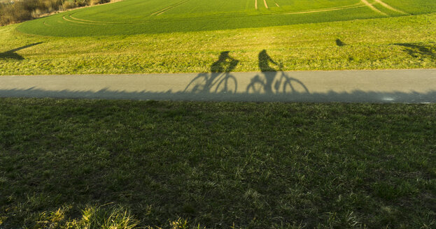 Schatten eines Paares auf Fahrrädern - UUF004567