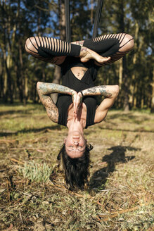 Frau übt Luft-Yoga im Freien - MGOF000267