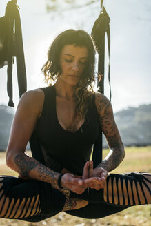 Frau übt Luft-Yoga im Freien - MGOF000268
