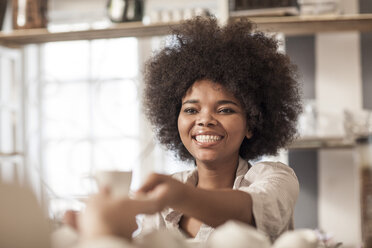 Young woman at coffee bar serving coffee to client - ZEF006195