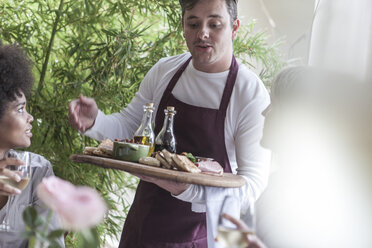 Kellner serviert Essen für Freunde beim Mittagessen im Restaurant - ZEF006202