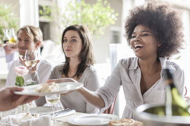 Freunde beim gemeinsamen Mittagessen im Restaurant, draußen sitzend - ZEF006206