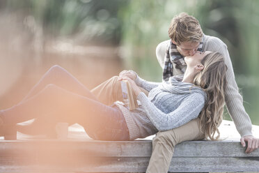 Junges Paar küsst sich auf einem Steg am See - ZEF006171