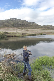 Young man fishing at a lake - ZEF005781