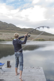 Young man fishing at a lake - ZEF005782