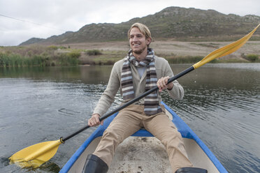 Porträt eines glücklichen jungen Mannes beim Paddeln auf einem See - ZEF005784