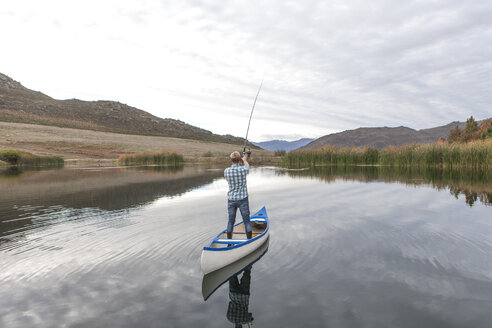 Young man in a canoe fishing on lake - ZEF005789