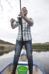 Junge Angler in einem Kanu auf einem See stehend - ZEF006173