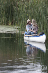 Junges Paar sitzt in einem Kanu auf einem See, Gesicht an Gesicht - ZEF005799