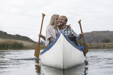 Happy young couple in a canoe on a lake - ZEF005803