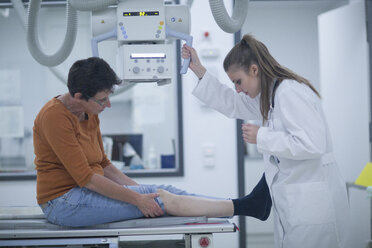 Junger Arzt mit Patient bei der Vorbereitung einer Röntgenaufnahme - SGF001649