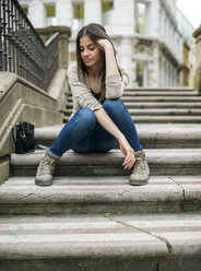 Spanien, Oviedo, junge Frau sitzt auf einer Treppe in der Altstadt - MGOF000270