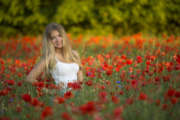 Germany, Bavaria, portrait of girl in a poppy field - YRF000083