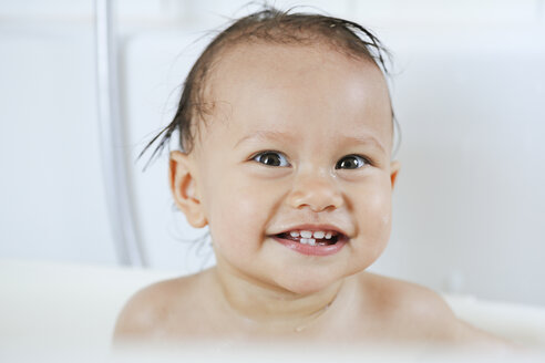 Porträt eines lächelnden kleinen Mädchens in einer Badewanne - DRF001654