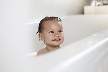 Portrait of smiling baby girl sitting in a bathtub - DRF001655