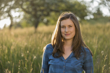 Portrait of young woman in a field in the evening - PAF001419