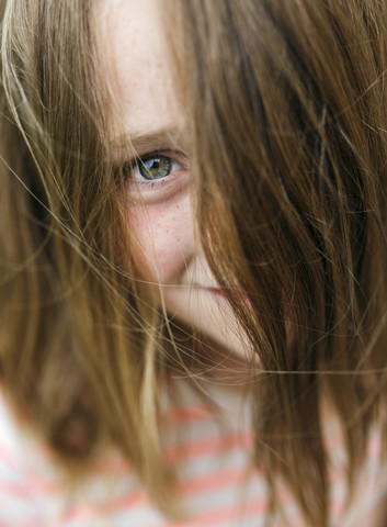 Portrait of smiling girl peeking through her hair stock photo