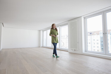 Junge Frau auf Wohnungssuche besichtigt moderne Wohnung - RBF002770