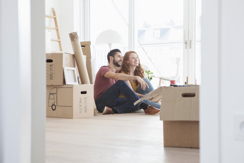 Young couple in new flat with cardboard boxes - RBF002862