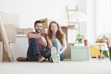 Young couple in new flat with cardboard boxes - RBF002780