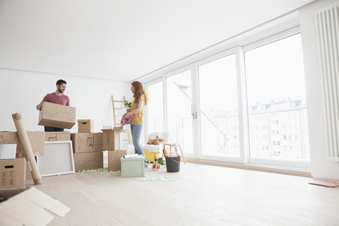 Junges Paar in neuer Wohnung packt Kartons aus, lizenzfreies Stockfoto