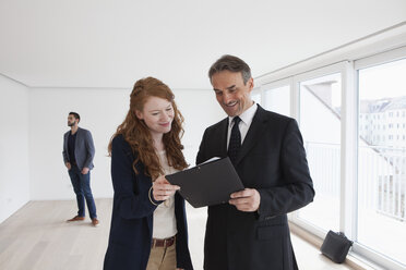 Young couple viewing flat with estate agent - RBF002791