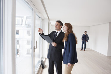 Young couple viewing flat with estate agent - RBF002794