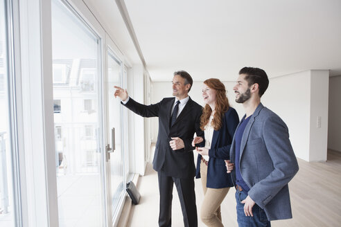 Young couple viewing flat with estate agent - RBF002795