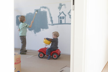 Kleiner Junge malt Haus und Baum an die Wand seines neuen Zimmers - RBF002828