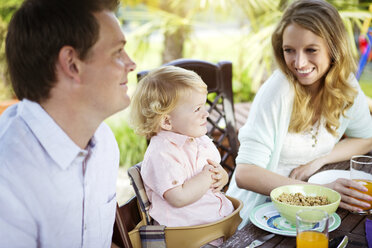 Happy family sitting at breakfast table - GDF000742