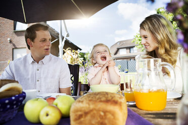 Die Familie sitzt am Frühstückstisch im Garten - GDF000745