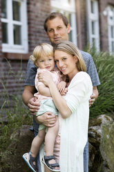 Parents with their little son in front of the house - GDF000753