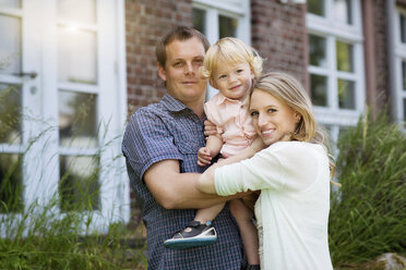Parents with their little son in front of the house - GDF000754