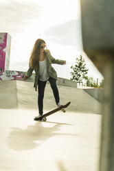 Junge Frau auf dem Skateboard in einem Skatepark - UUF004592