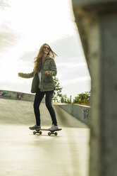 Junge Frau auf dem Skateboard in einem Skatepark - UUF004593
