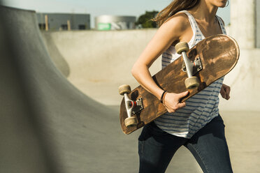 Junge Skateboarderin läuft in einem Skatepark, Nahaufnahme - UUF004604