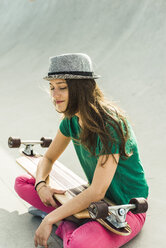 Smiling young skate boarder with closed eyes wearing a hat - UUF004616