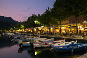 Italien, Venetien, Garda, Gardasee, Seepromenade mit Restaurants und Booten am Abend - LVF003463